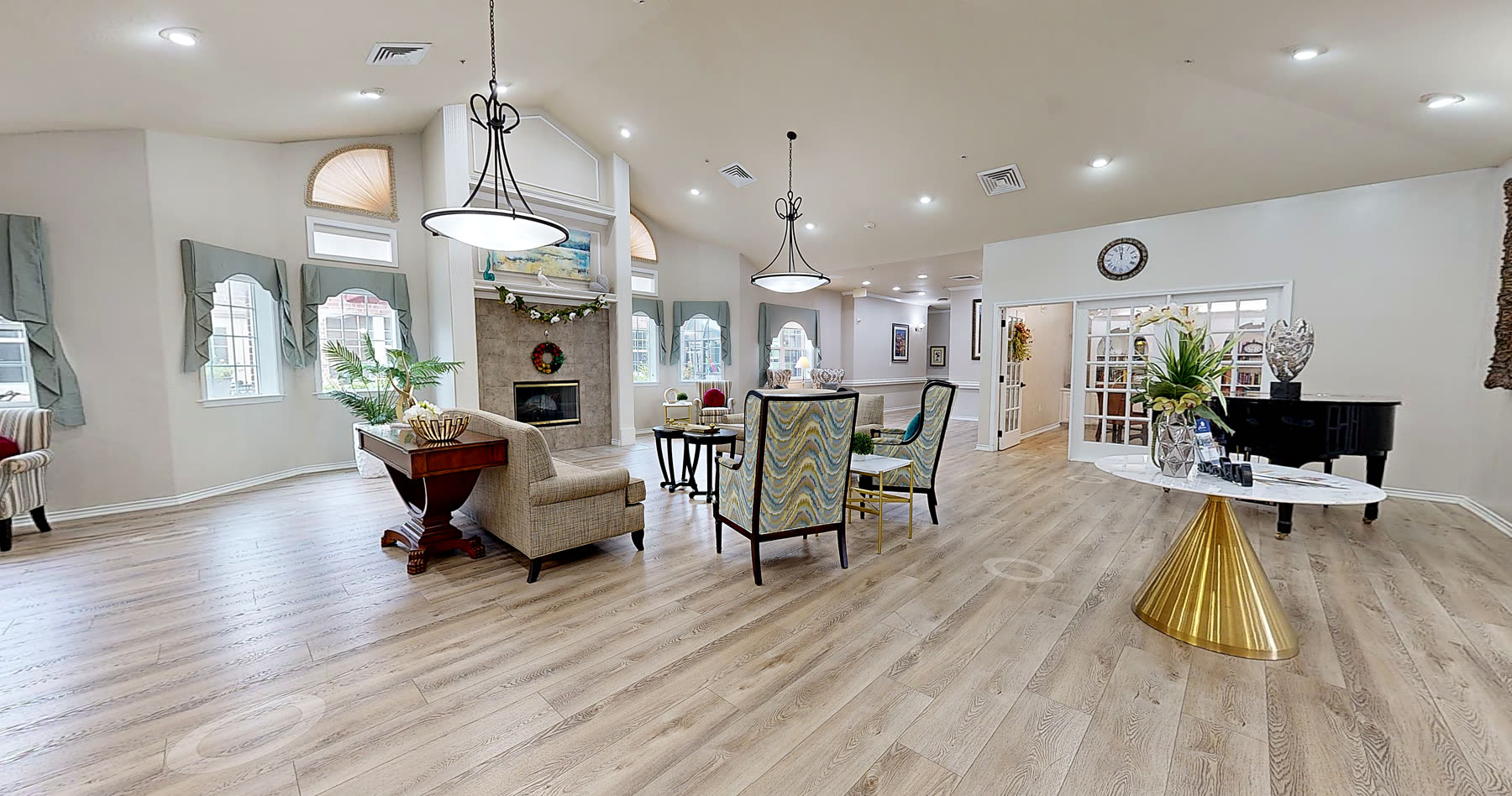 The great room at Magnolia Memory Care of Flower Mound, with fireplace seating and a grand piano